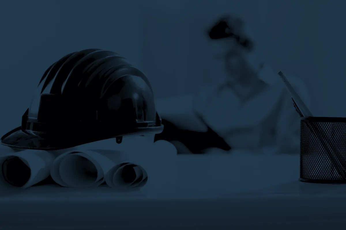 Capacete e pranchas de projeto sobre a mesa do escritório
